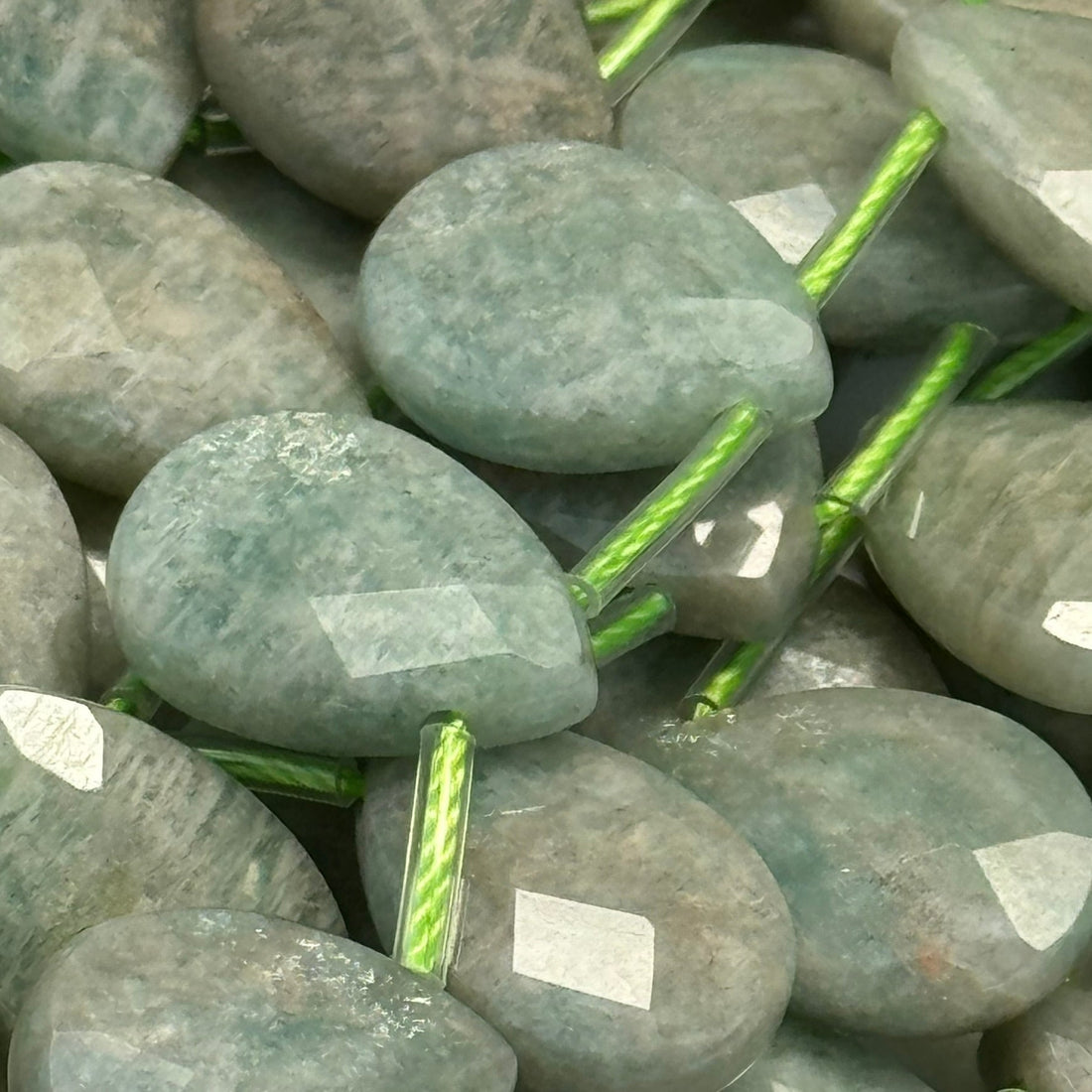 amazonite - in close up image with faceted finish and pear shape - all in strands of beads