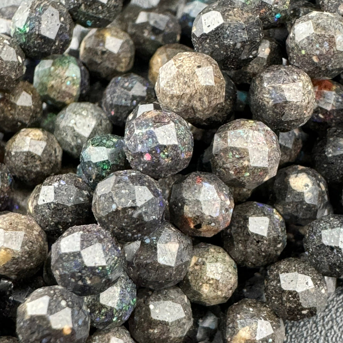 Black opal faceted round gemstone beads displaying vibrant color play
