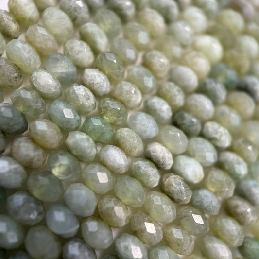 Natural jadeite and nephrite jade gemstones displayed in various green, white, and lavender colors with polished and carved finishes.