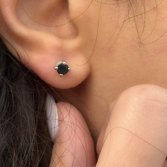 Handmade round sapphire earrings set with prongs in 925 sterling silver, showing the natural gemstones and polished silver settings.