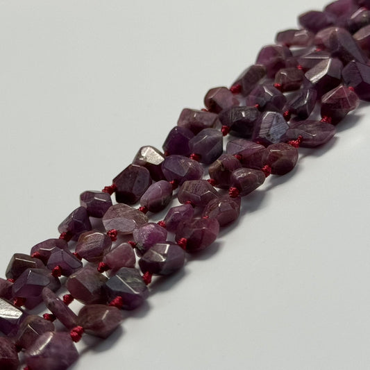 Natural red ruby compared with laboratory-grown, treated, and imitation ruby gemstones during gemological examination.