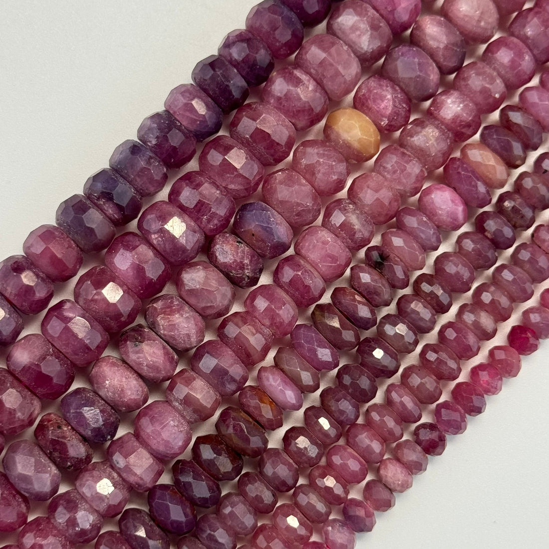 Different types of natural ruby showing vivid red, pinkish-red and purplish-red colors alongside a cabochon star ruby.