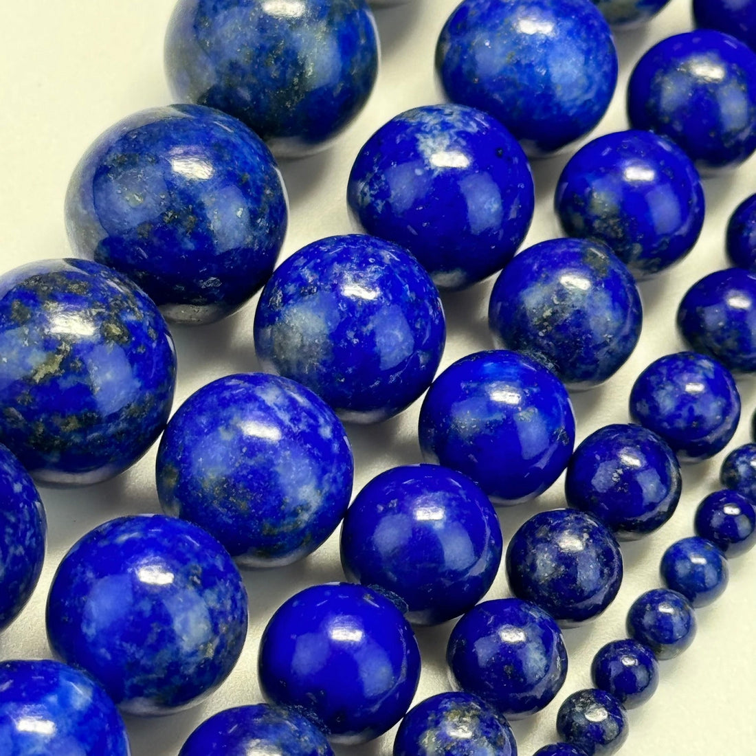 Natural lapis lazuli showing deep blue color with golden pyrite flecks and natural calcite patterns.
