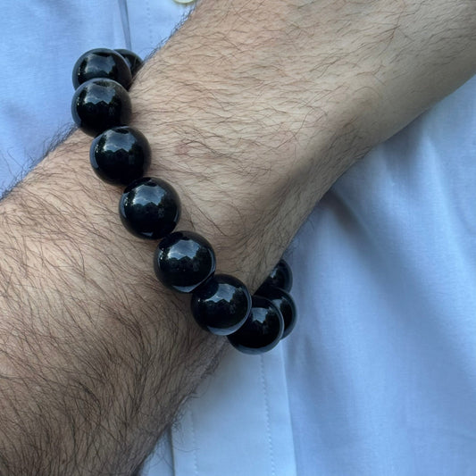 Natural black obsidian volcanic glass with a polished surface and characteristic dark glassy appearance.